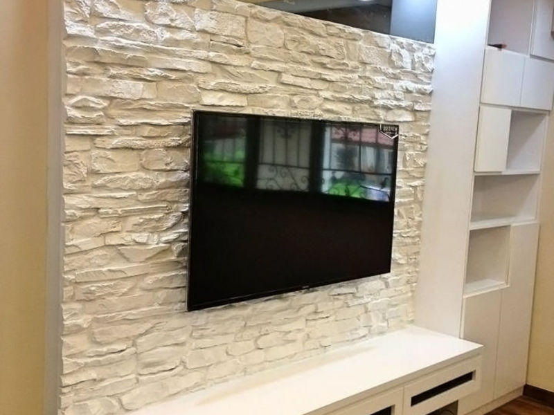 Отделка искусственным камнем стены как фон за телевизором